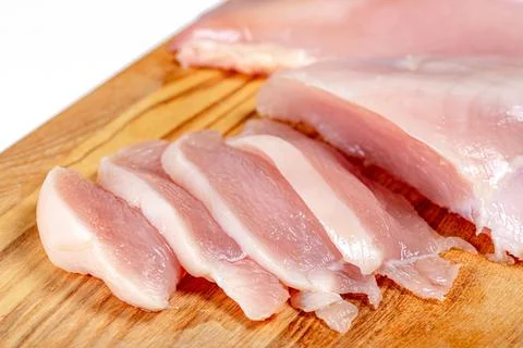 Close up of raw chicken fillet chunks on wooden kitchen board Stock Photos