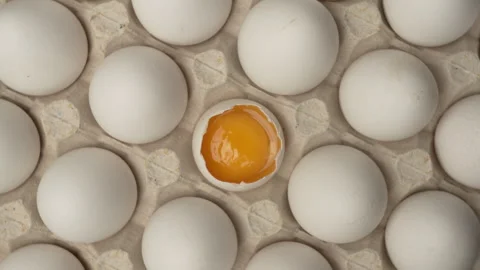 Close-up of raw chicken organic eggs in egg cardboard box. One egg cracked .. Stock Footage 340812094