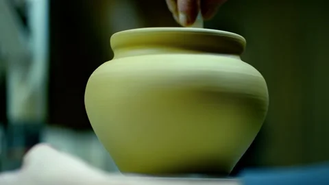 Close-up of a raw clay pot spinning on a potter's wheel. Stock Footage 328925286