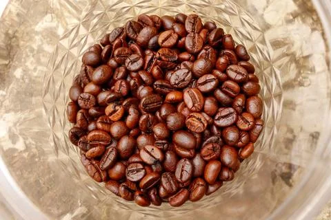 Close-up of raw coffee beans spread on a wooden surface, highlighting natur.. Stock Photos