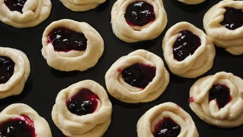 Close-up raw dough buns stuffed with berry jam. Stock Footage 243694310