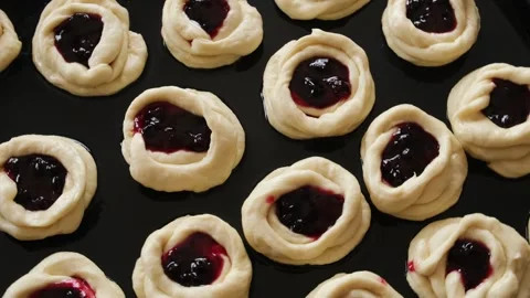 Close-up raw dough buns stuffed with berry jam. Stock Footage 244766018