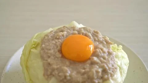 Close-up of a raw egg yolk on top of minced meat on a plate Stock Photos