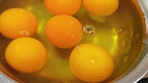 Close-up of raw egg yolks and egg whites in a bowl. Video stock 342781567