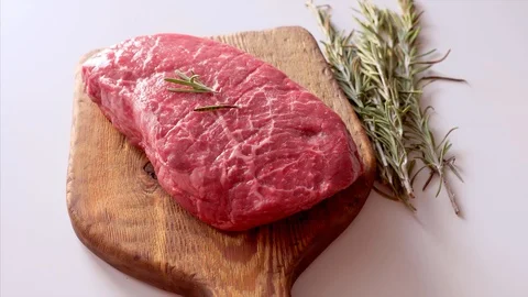 Close Up of Raw Fresh Steak Served with Rosemary on Rustic Wooden Board Stock Footage 120187241
