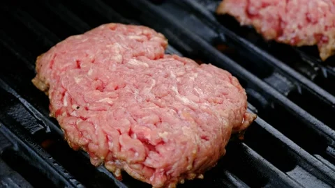 Close up of raw hamburger cooking on a grill Stock Footage 138452946