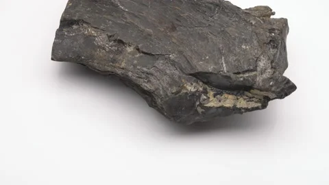 Close up of Raw Jet stone rock rotating on white background Видео 141601013