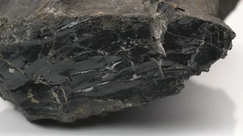 Close up of Raw Jet stone rock rotating on white background Video stock 141608309