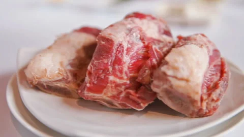 Close Up Of Raw Lamb Shank On White Plate, slider shoot Stock Footage 130408880