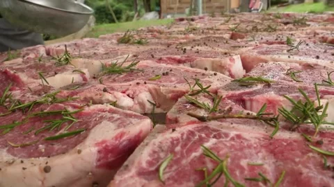 Close-up of Raw Marbled Beef Steaks Seasoned with Rosemary and Peppercorns for O Stock Footage 338213032