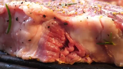 Close-up of Raw Marinated Beef Steak Seasoned with Peppercorns and Rosemary on O Stock Footage 338213107