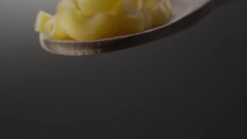 Close-up of Raw Pasta Shells on a Wooden Spoon Stock Footage 287379732
