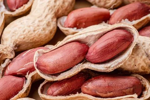 Close-up of raw peanuts in shells on wooden surface Stock Photos