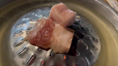 Close-up of raw pork being steamed in a metal container. Stock Footage 326439062