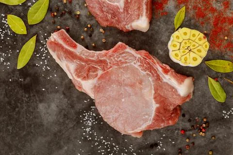 Close up of raw pork chops rib with spices on gray background. Stock Photos