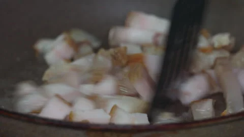 Close up of Raw Pork Lard Cubes Sizzling and Frying in a Hot Nonstick Frying Pan Stock Footage 339630473