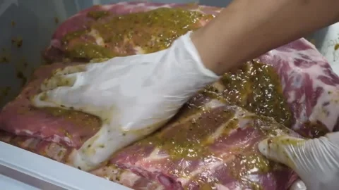 Close-up of Raw Pork Ribs Being Marinated with Green Herb Seasoning Sauce Stock-Footage 332810872