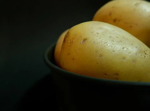 Close up of raw potatoes on a dark background  写真素材