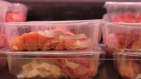 Close up raw red meat in plastic boxes showcased in a butcher shop Stock Footage 140990996
