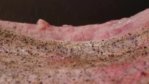Close-up of raw seasoned beef steak being prepared for barbecue grilling Stock Footage 338212384