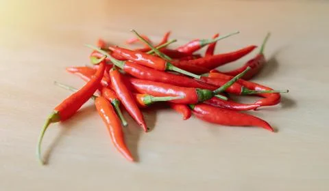 Close-up of raw spicy red chilli peppers on the wooden table. Stock Photos