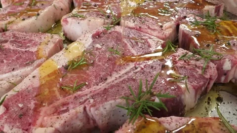 Close-up of Raw T-bone Steaks Marinated with Oil and Fresh Rosemary Ready for Ba Stock Footage 338213051
