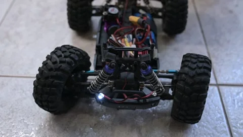 Close-up of an RC car chassis with visible electronics as the wheels turn left Stock Footage 319503682