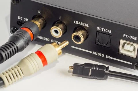Close-up of RCA connectors plugged into an audio device and an optical cable. Stock Photos