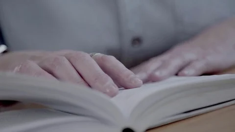 Close-up of reading a book and flipping pages. Hands of a senior Video stock 72077490