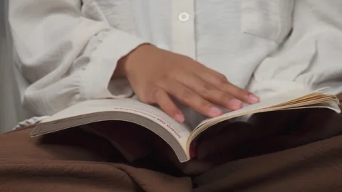 Close up reading book on laps Stock Footage 277013550