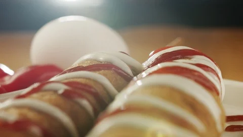 Close-up on ready-made corn dog pouring mustard. Slow motion video Stock Footage 117584875