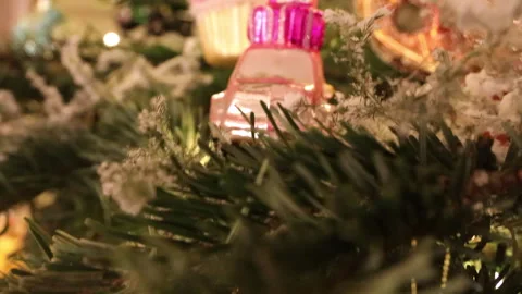 Close-up of a real Christmas tree decorated with glowing garlands and vintage gl Stock Footage 325966230