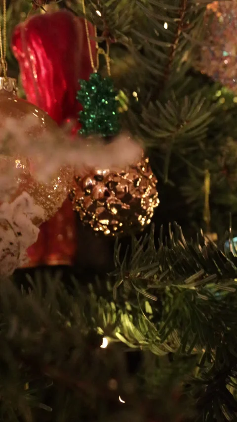 Close-up of a real Christmas tree decorated with glowing garlands and vintage gl Stock Footage 325985973