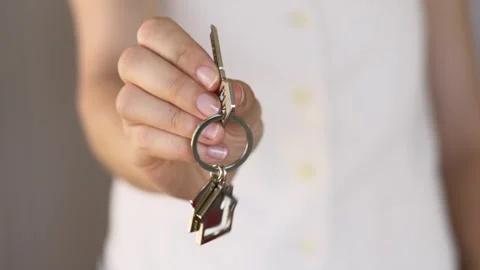 Close-up of real estate agent holding house keys in one hand. Focus on the Stock-Footage 321815065