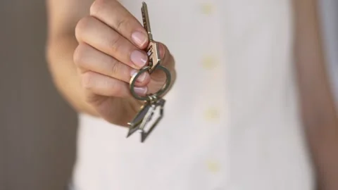 Close-up of real estate agent presenting house keys, with the keyring held Stock Footage 330486349