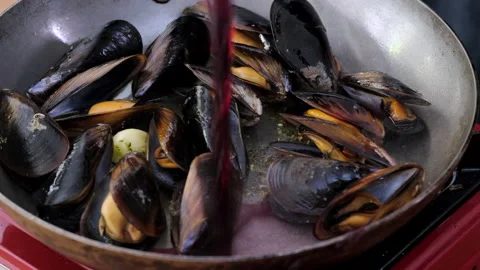 Close up up real time view in deep frying pan cooking sea mussels Stock Footage 141453814
