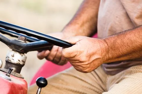 Close Up Of Real Worker Hands  with Tractor Steering Wheel Stock Photos