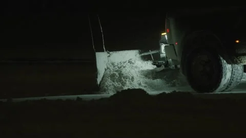 Close up of rear end of snow plow truck plowing snow in dark parking lot Stock Footage 234033795