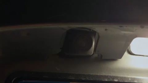 Close-up rear parking camera mounted under vehicle body with bright light and Stock Footage 338133995