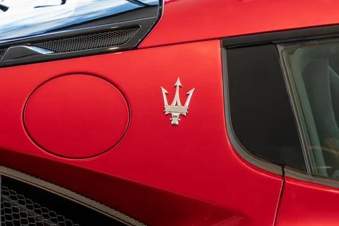 Close up of rear side view of red Masarati sports car with trident brand logo Stock Photos