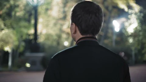 Close-up, Rear View A Man Walking through a Night Park Stock Footage 97742941