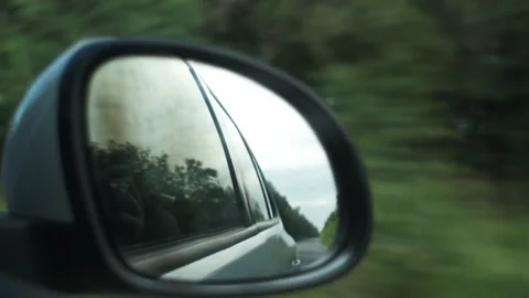 Close up of rear view side mirror of automobile car while driving along road Stock Footage 284912529