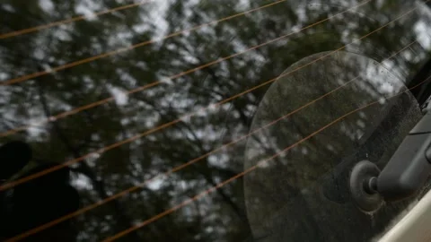 Close-up of a rear windshield wiper cleaning the wet glass 스톡 동영상 323246223