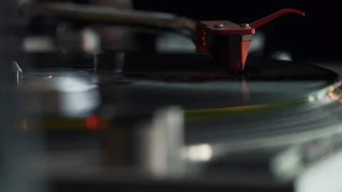 Close up of a record playing on a turntable with a chrome arm and red cartridge Stock Footage 127323300