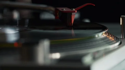 Close up of a record playing on a turntable with a chrome arm and red cartridge Stock Footage 127323390
