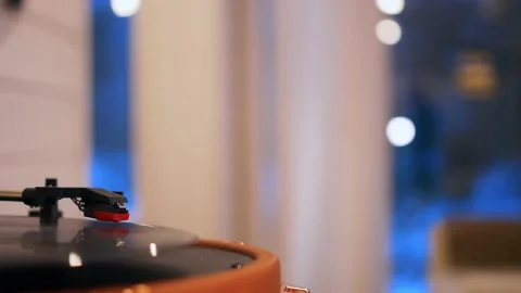 A close-up of a record spinning in a player, in the background lights in a Stock Footage 176545144