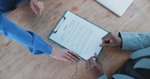 Close up of a recruiter handing over a contract to candidate Stock Footage 208045725