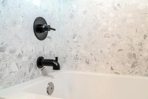 Close up of rectangular bathtub and wall mounted faucet with single lever handle 스톡 사진
