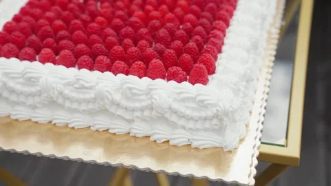 Close-up of a rectangular raspberry cake topped with fresh red berries and 스톡 동영상 320073264