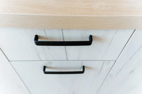 Close up of rectangular wooden cabinet with black handles 스톡 사진